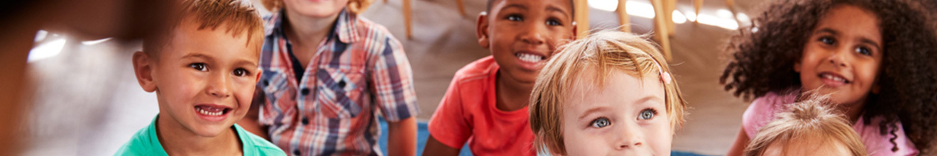 group of smiling children sitting on a carpet