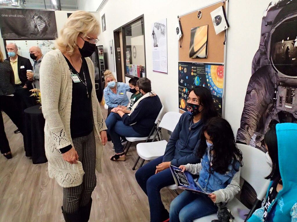 Teacher Kathy Jackson talks to a student about her interest in our solar system.